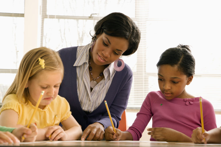 Teaching assistant helping young pupil